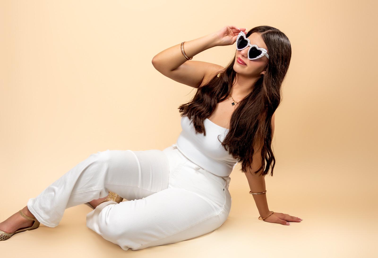 Karolina con lentes de corazón y un elegante conjunto blanco